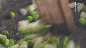 鍋中油7成熱時，入青豆、筍丁翻炒，然后加糯米飯加鹽均勻翻炒。