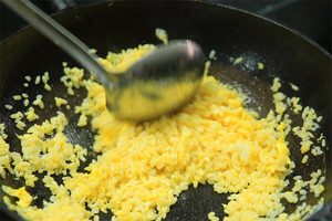 大火加熱炒鍋，再入油，燒到四至五成熱時(shí)倒入雞蛋液，在未凝結(jié)之前，加米飯煸炒，不停翻炒并用鍋鏟將成塊的米飯碾開、撥散。