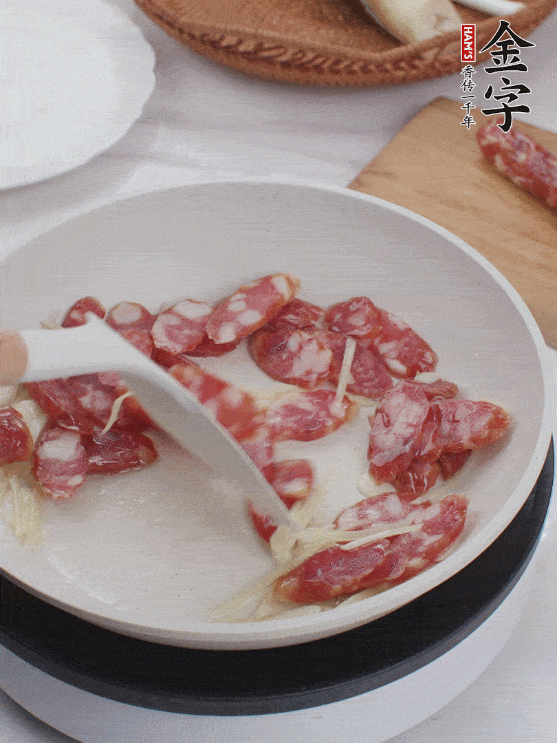 油溫3成熱時(shí)，下姜絲、蒜片、香腸炒出油脂。