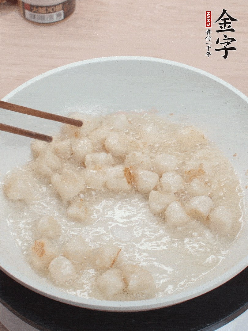 油溫4成熱，鮮貝蘸干淀粉下鍋煎，一面微黃后翻面。