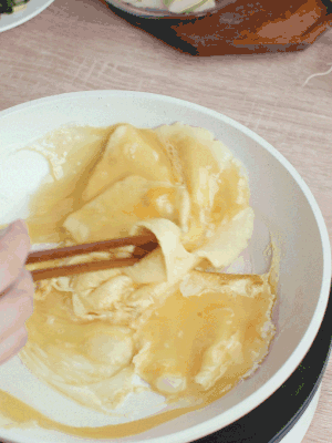 油6成熱時(shí)，下雞蛋液，邊緣凝固時(shí)翻拌成塊狀。