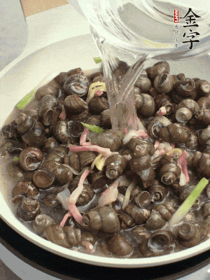 倒處理干凈的螺螄翻炒，加3勺料酒。加清水蓋過螺螄，中火蓋蓋煮5分鐘。