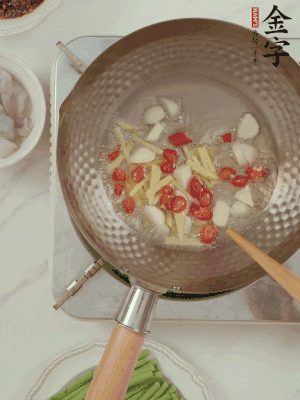 油7成熱時，下大蒜粒、姜絲、小米辣煸香。