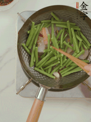 下掰好的缸豆段翻炒，略燜煮。