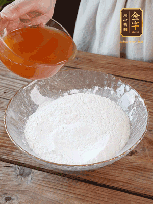 轉(zhuǎn)化糖漿、枧水、花生油攪拌均勻，加入面粉混合，醒發(fā)2小時(shí)。捏成23g一個(gè)的小球