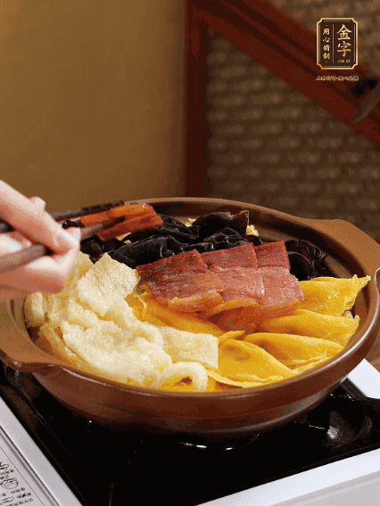 砂鍋底部鋪上娃娃菜，依次擺上肉皮、蛋餃、黑木耳、火腿